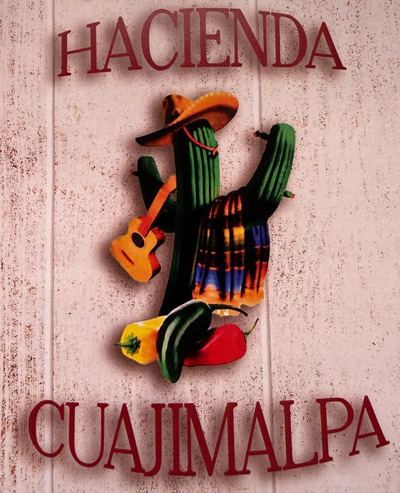 Cactus with guitar and hat, text: Hacienda Cuajimalpa on wooden background.