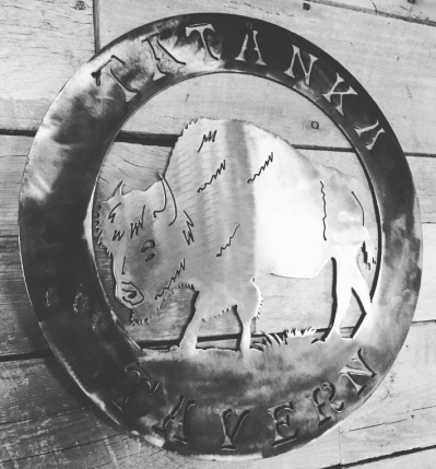Metal sign with a buffalo cutout, reads 'Tatanka Tavern.'